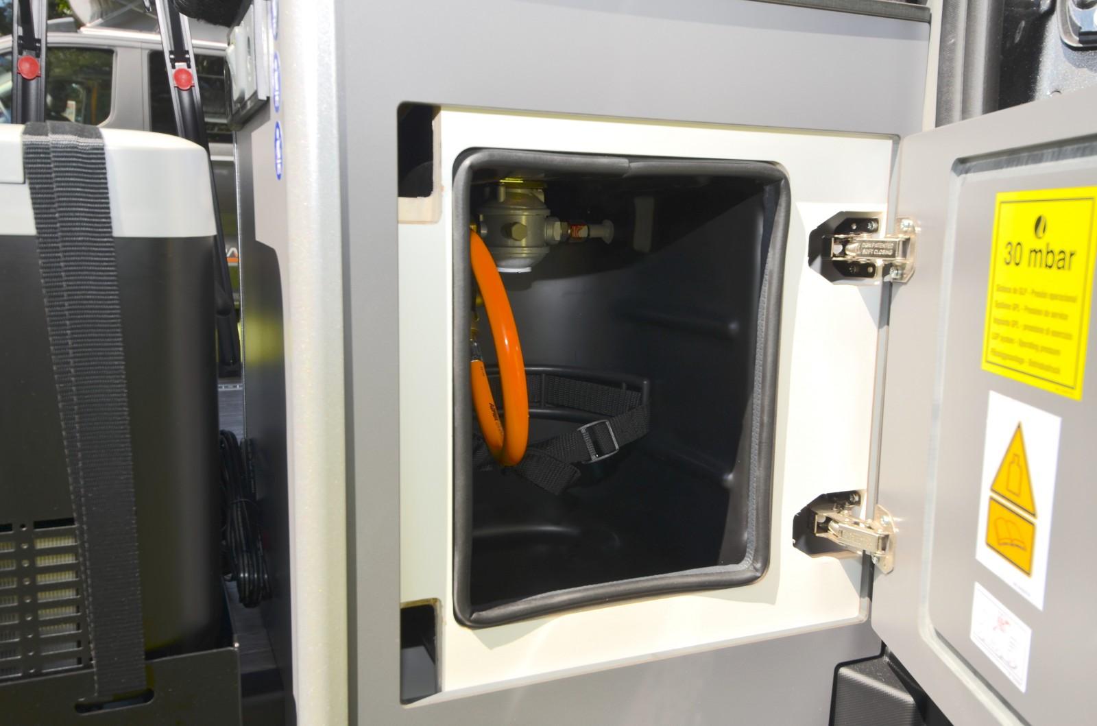 Le coffre à gaz est accessible depuis le côté gauche du van (porte latérale ouverte).