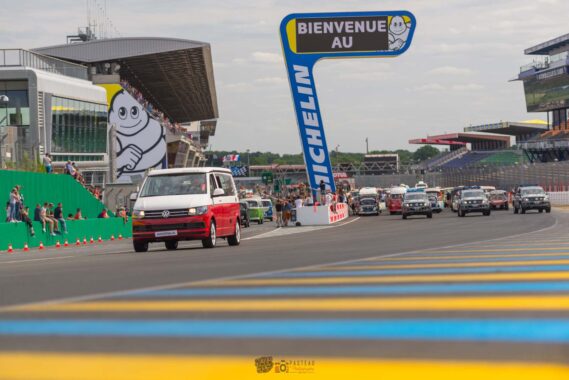 Le Kepler Sixty s'élance sur le circuit du Mans Bugatti, suivi par des centaines de combis réunis pour la grande parade du Super VW Fest