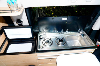 À gauche de la cuisine, la réfrigérateur avec ouverture par le dessus est une option.