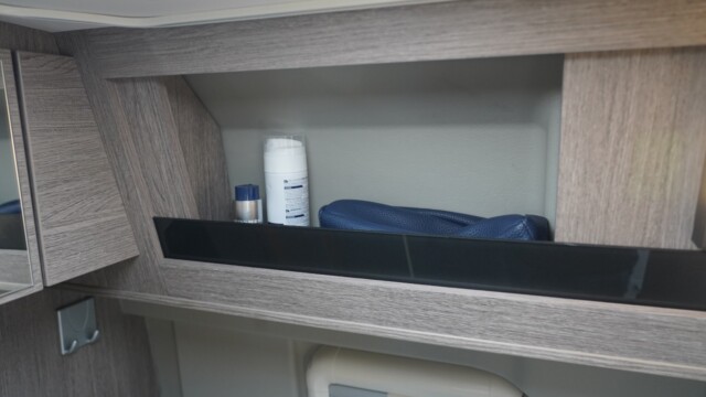 Dans la salle d'eau, un large rebord retient les objets du quotidien.