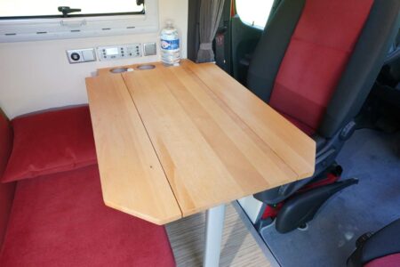 CS REISEMOBILE - Table en bois massif avec deux rabats de 15 cm de chaque côté. Très stable, elle coulisse le long d'un rail fixé au support bouteilles.