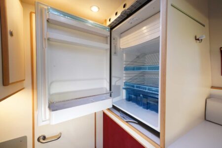 CS REISEMOBILE - Située au-dessus de la porte, la poignée d'ouverture est sans doute un peu haute, vu la position du frigo.