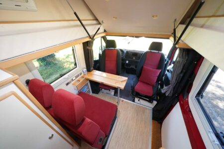 CS REISEMOBILE - Le salon se montre assez spacieux compte tenu de la longueur du véhicule. Il faut noter le très large accès vers la porte coulissante totalement libérée du meuble cuisine.