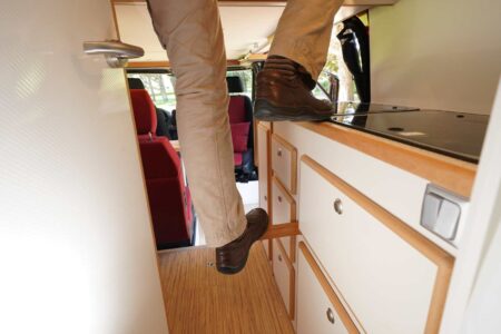 CS REISEMOBILE - Pas échelle encombrante pour le lit haut. L'accès nécessite de prendre appui sur une solide tringle en bois et sur le meuble cuisine.