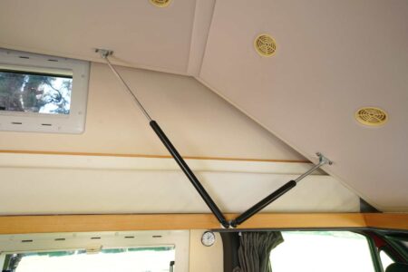 CS REISEMOBILE - De puissants vérins soutiennent le sommier articulé du lit de pavillon. Leur compression à la descente demande un bon coup de main.