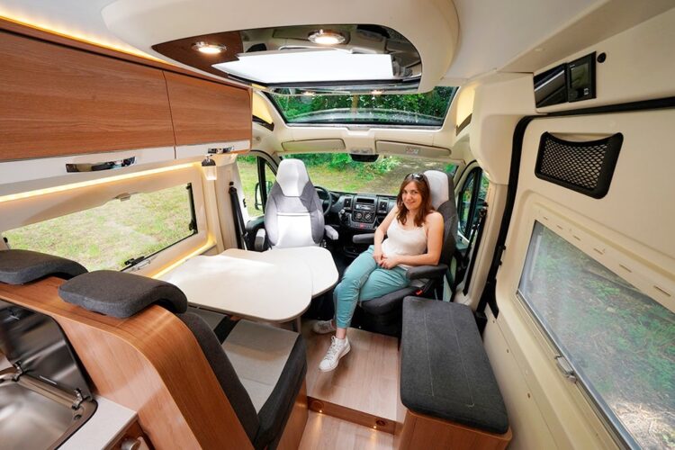 Rapido V62. Au salon, le pouf latéral constitue une assise supplémentaire. Il permet également la mise en place d'un lit d'appoint.