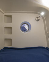 Rangements, rideau et éclairage sont prévus dans chacune des deux couchettes pour enfants. En prime : un hublot est installé dans l'une des deux. Crédit photo : Tim Hall.