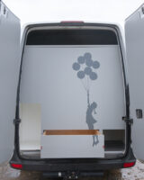 Depuis l'arrière du véhicule, d'autres rangements sont prévus pour ranger le matériel encombrant. Le dessin s'inspire ici de "La petite fille au ballon", oeuvre de street-art signé Banksy.