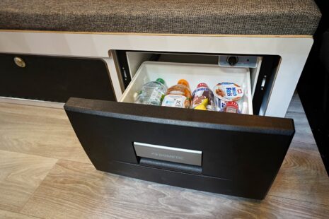 Sous la banquette, face à la porte coulissante, le frigo tiroir 20 L reste accessible une fois le lit déployé