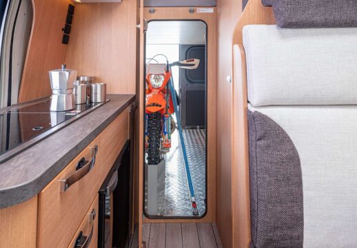 Une porte hermétique sépare 2 espaces bien distincts. Véritable garage à l’arrière, confortable zone de vie à l’avant : salle d’eau, cuisine, dînette 4 places et accès au maxi couchage au dessus du garage.