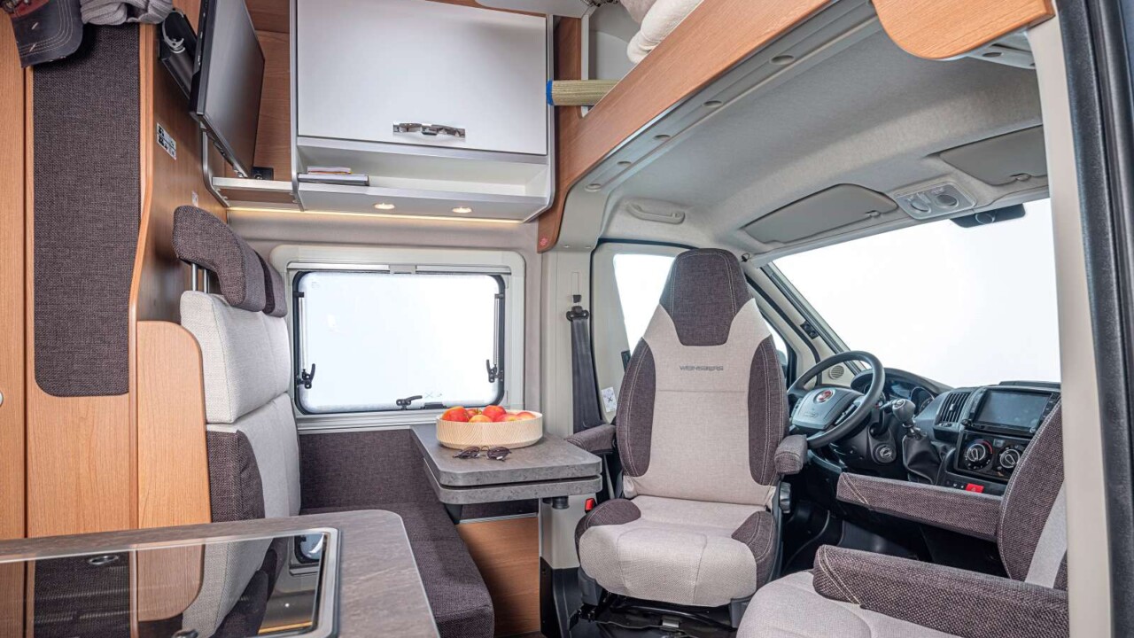 Dînette pour 4 et grande zone de rangement au dessus de la cabine