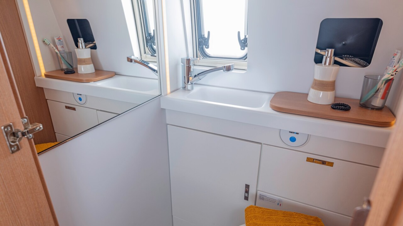 Salle d'eau avec douche, lavabo, WC à cassette et très grand miroir