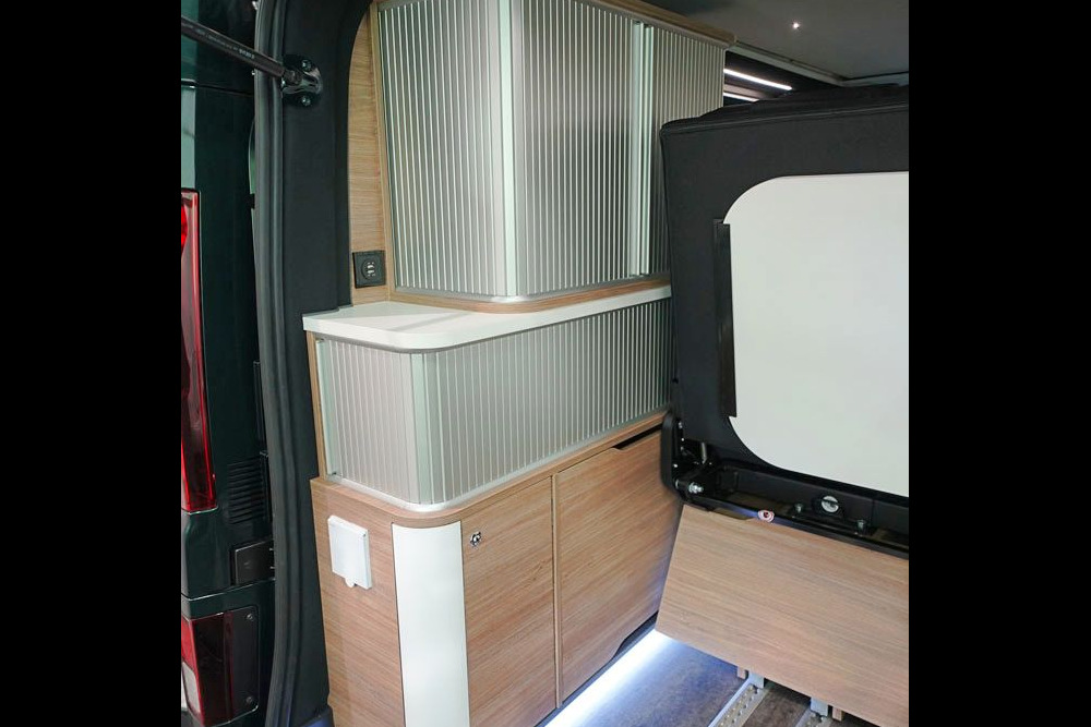 Les rideaux à lamelles du meuble de rangement dissimulent des volumes bien compartimentés.