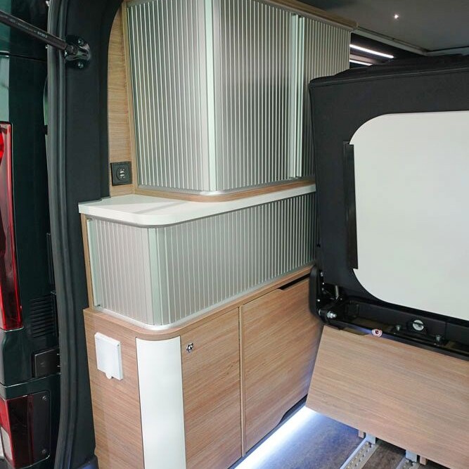 Les rideaux à lamelles du meuble de rangement dissimulent des volumes bien compartimentés.