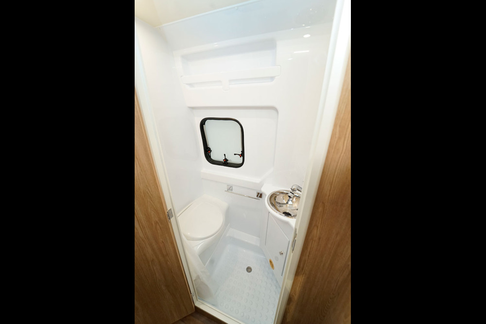 Dans le cabinet de toilette, baie de série pour l'aération et habillage thermoplastique pour un entretien facilité.