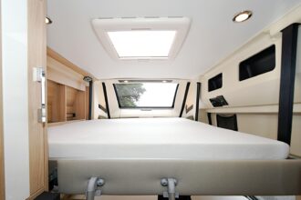 Accessible par une échelle, le lit de pavillon électrique offre un couchage de 190 x 125 cm et de nombreux espaces de rangements sur les côtés.