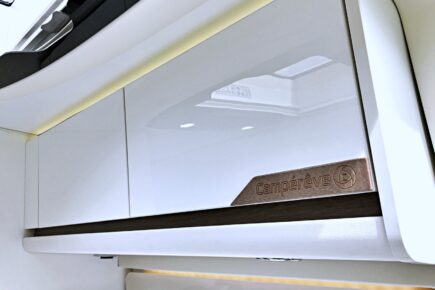 Sur le meuble de pavillon du salon, la signature Campérêve est moulée en bois massif, et le soubassement en revêtements grain cuir.