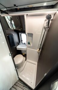 Menfys 3 Plus - nouvelle salle d'eau. L'accès se fait par une porte battante, et non pas coulissante. Une caractéristique réservée au haut de gamme. De même, il faut se satisfaire d'un rideau ceinturant la douche...