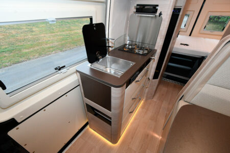 Ici relevé, en abattant vient protéger les deux feux gaz en saillie. Il constitue une surface de travail supplémentaire, tout comme la tablette rabattable située en bout de meuble.