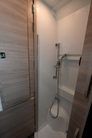 Lorsque l'on souhaite utiliser la douche, la penderie qui occupe l'espace vient pivoter au-dessus du lit. Dans le même temps, elle isole d'éventuels regards indiscrets à travers les baies arrière.