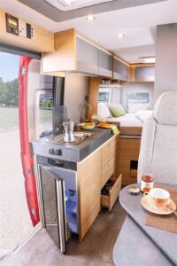 Bien proportionné le bloc cuisine héberge de nombreux rangements, ainsi qu'un frigo à ouverture droite et gauche. Le planche à découper se positionne sur l'évier pour agrandir le plan de travail.