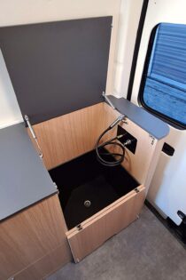 La technique de l'extrudage permet de concevoir des douches sur mesure. Ici discrètement intégrée dans le meuble avec un système de vérin.