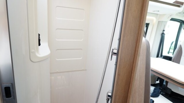 La cloison de douche apparaît décaissée en haut pour dégager de la place au niveau des épaules. L'espace reste compté néanmoins.