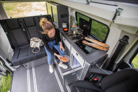 Le bloc cuisine latéral avec réfrigérateur 42 L, plaque et évier, des réservoirs de 50 L d'eau propre et 30 litres d'eaux usées