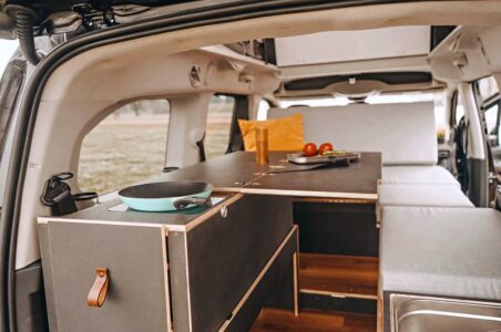 La kitchenette est réglable en hauteur, son plan de travail se transforme en table à manger ou station de travail