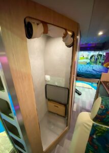 La cabine de douche abrite aussi une trappe derrière laquelle se cachent les toilettes sèches. Un espace fermé par un rideau à fermeture éclair.