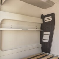 Des niches de rangements avec élastiques sont intégrées à la chambre.