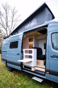 Rencontre du design et du fonctionnel : une porte du mobilier devient tablette et le meuble cuisine traversant.