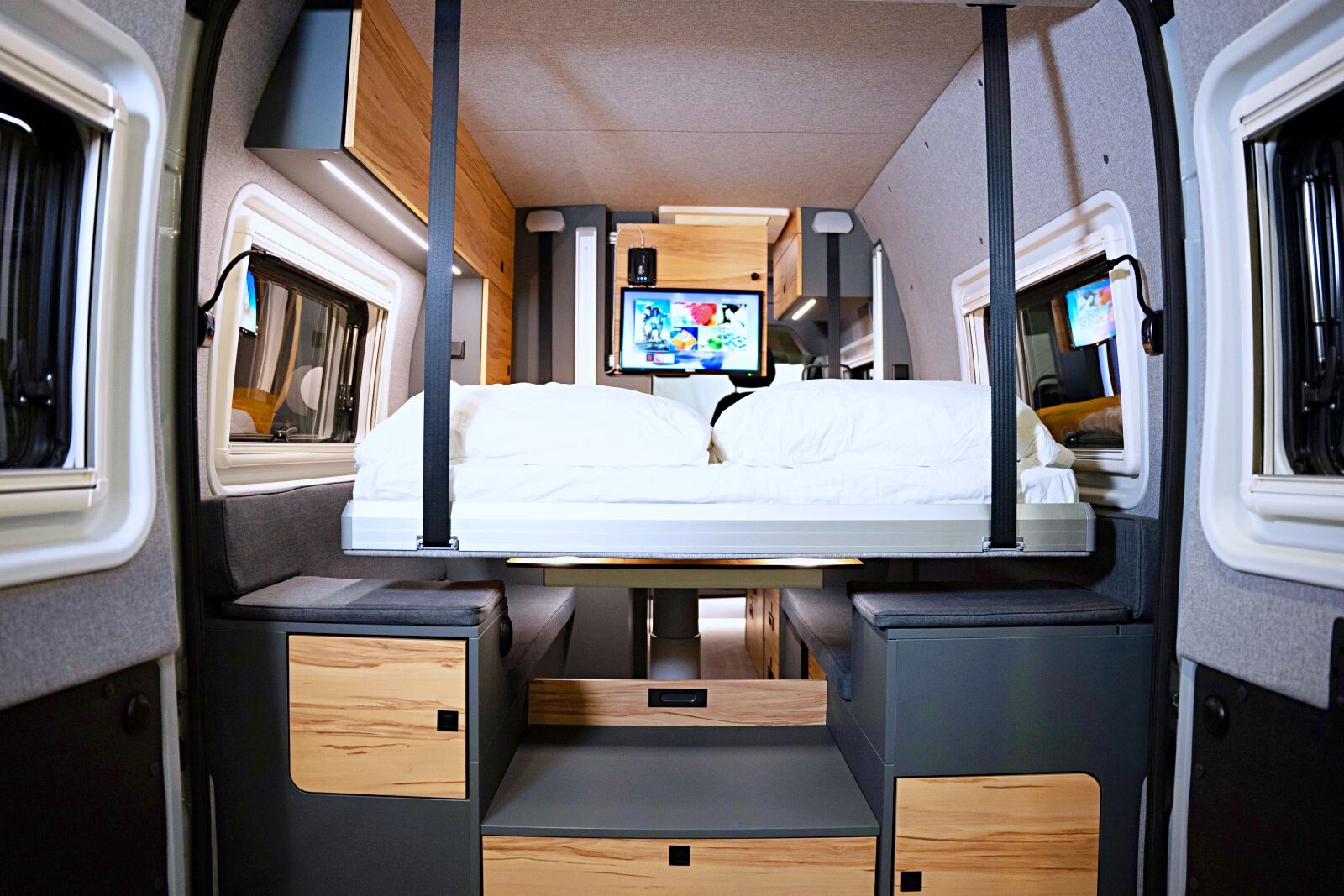 Le lit descend juste à 2 cm de la table centrale fixe. Le caisson de rangement amovible au premier plan est en option.