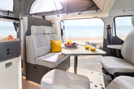 Le matelas du lit d'appoint se range dans le placard étroit, juste derrière la banquette, accessible par une porte à lamelles coulissante Westfalia Kelsey Ford custom