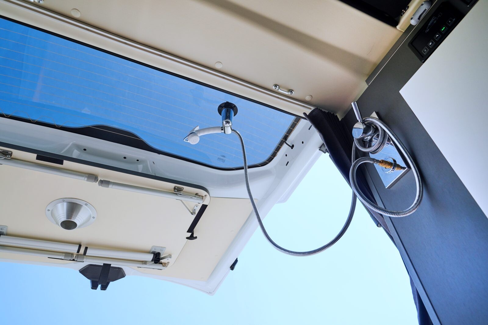 Une utilisation extérieure de la douche offrira davantage d'aisance de mouvement. Un support permet de fixer la douchette sur le hayon