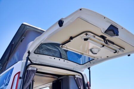 La table de 61 x 92 cm multifonctions (dînette sur un pied, support du lit d'appoint mi-hauteur, table extérieure 4 pieds) se loge facilement dans le hayon