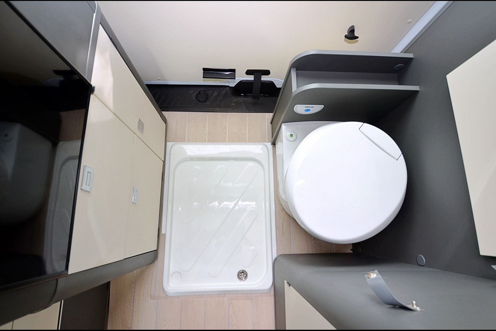 Un rideau de douche "entonnoir" amovible vient s'accrocher sur les parois pour protéger des éclaboussures. La cassette du WC est accessible côté hayon