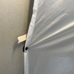 Des pressions maintiennent le rideau de douche en place.