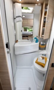 Le lavabo est monté sur une cloison pivotante et vient se placer au-dessus du W.-C. pour libérer l'espace douche.