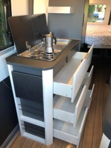 Format du véhicule oblige, le plan de travail se forme à l'aide des abattants en verre de l’évier et du réchaud et/ou de la petite tablette latérale escamotable.