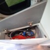Dans le passage entre l'avant et l'arrière, un profond meuble permet d'entreposer divers accessoires (douchette, tuyau de raccordement au 220/230V, etc.)