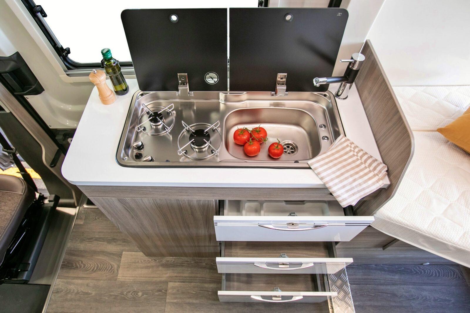 Le bloc cuisine abrite un réchaud 2 feux au gaz et un frigo de 70 L. Le R570 dispose de 100 L d'eau propre.