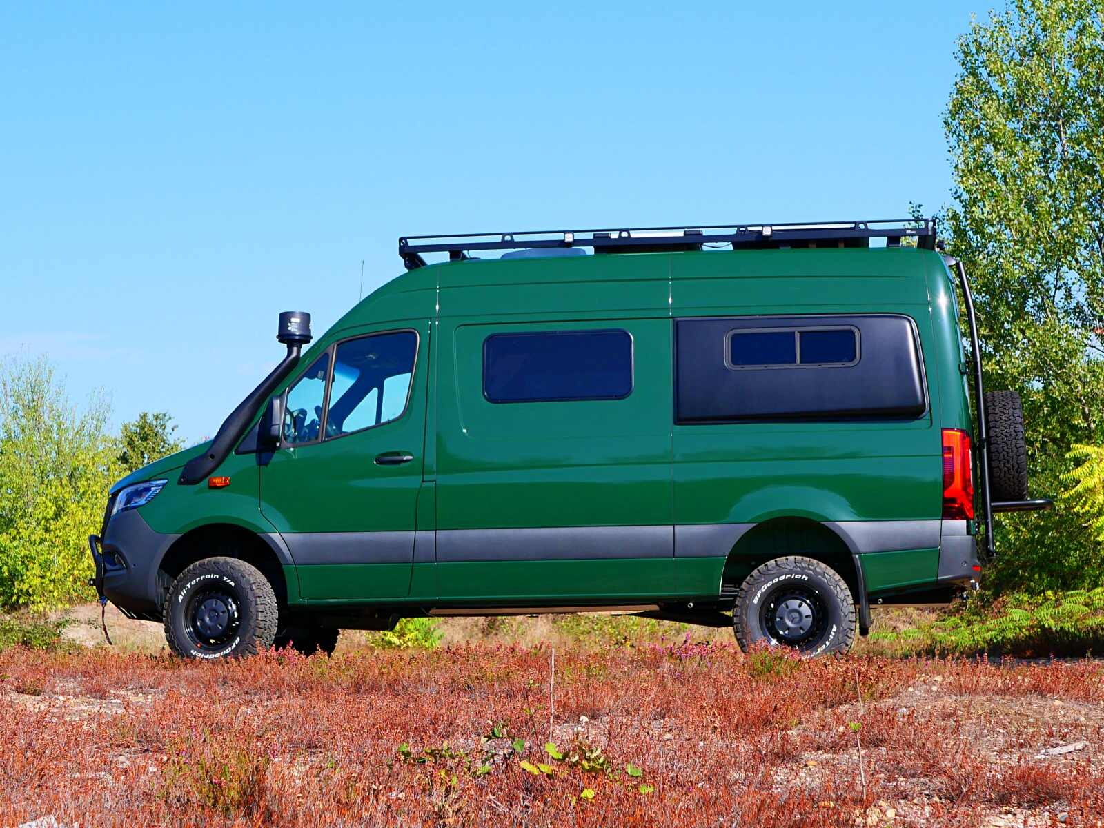 Un sprinter 4x4 prêt à arpenter tous les sentiers boisés en tenue de camouflages vert sapin.