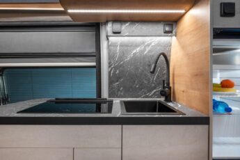 Grand et profond évier, robinet à col de cygne, plaques vitrocéramiques, plan de travail et crédence façon marbre... La cuisine offre de luxueuses prestations.