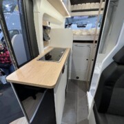 Le bloc cuisine intègre à son bout un frigo 95 L, sous un plan de travail fixe.