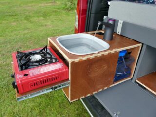 Le circuit d'eau est alimenté par un réservoir de 5 L. La profondeur de la bassine souple affiche 4 cm repliée, 14 cm dépliée après avoir tiré le réchaud vers l'extérieur.