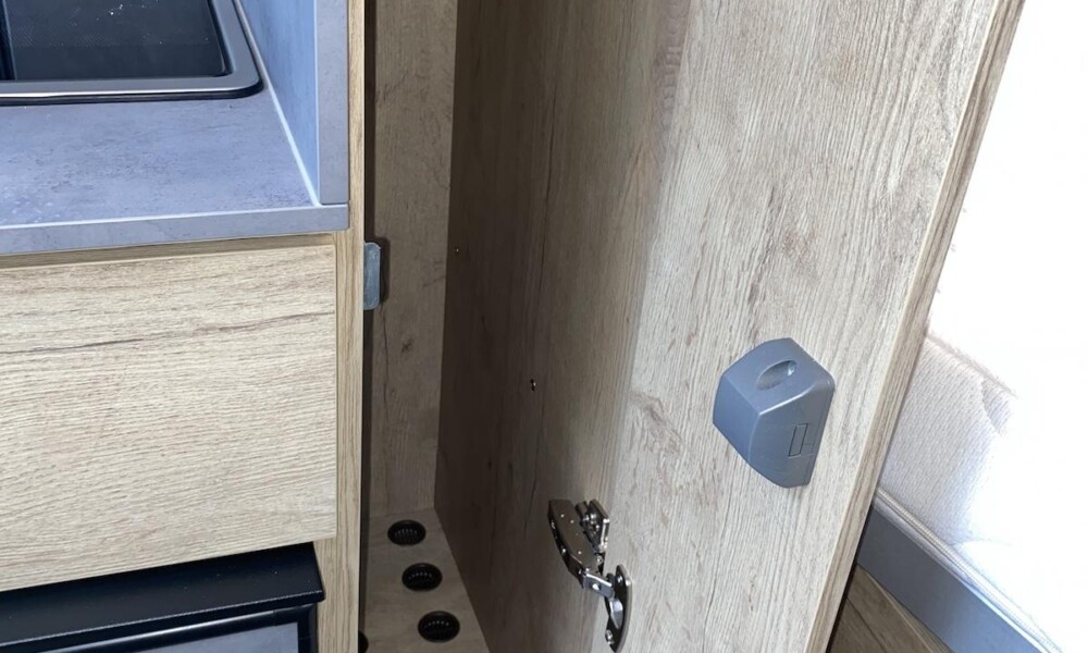 Entre la cuisine et la chambre, une penderie étroite mais haute est installée (77 cm de hauteur sous tringle, 17 cm de largeur, 45 cm de profondeur).