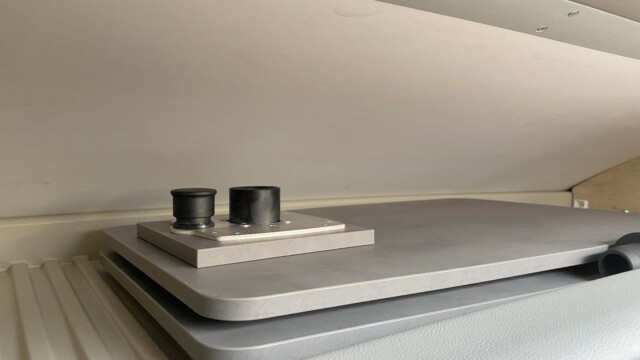 La table (84,5 x 42 cm) et son pied peuvent être rangés dans la profonde niche qui surplombe la cabine. Le rangement se ferme à l'aide d'une porte.