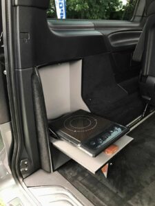 Une plaque de cuisson à induction, rabattable contre la paroi, assure l'homologation du véhicule en VASP Caravane.