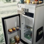 Le réfrigérateur, dans l'entrée, profite d'un système d'ouverture des deux côtés. Il est donc accessible depuis l'intérieur comme l'extérieur du véhicule (porte latérale ouverte).